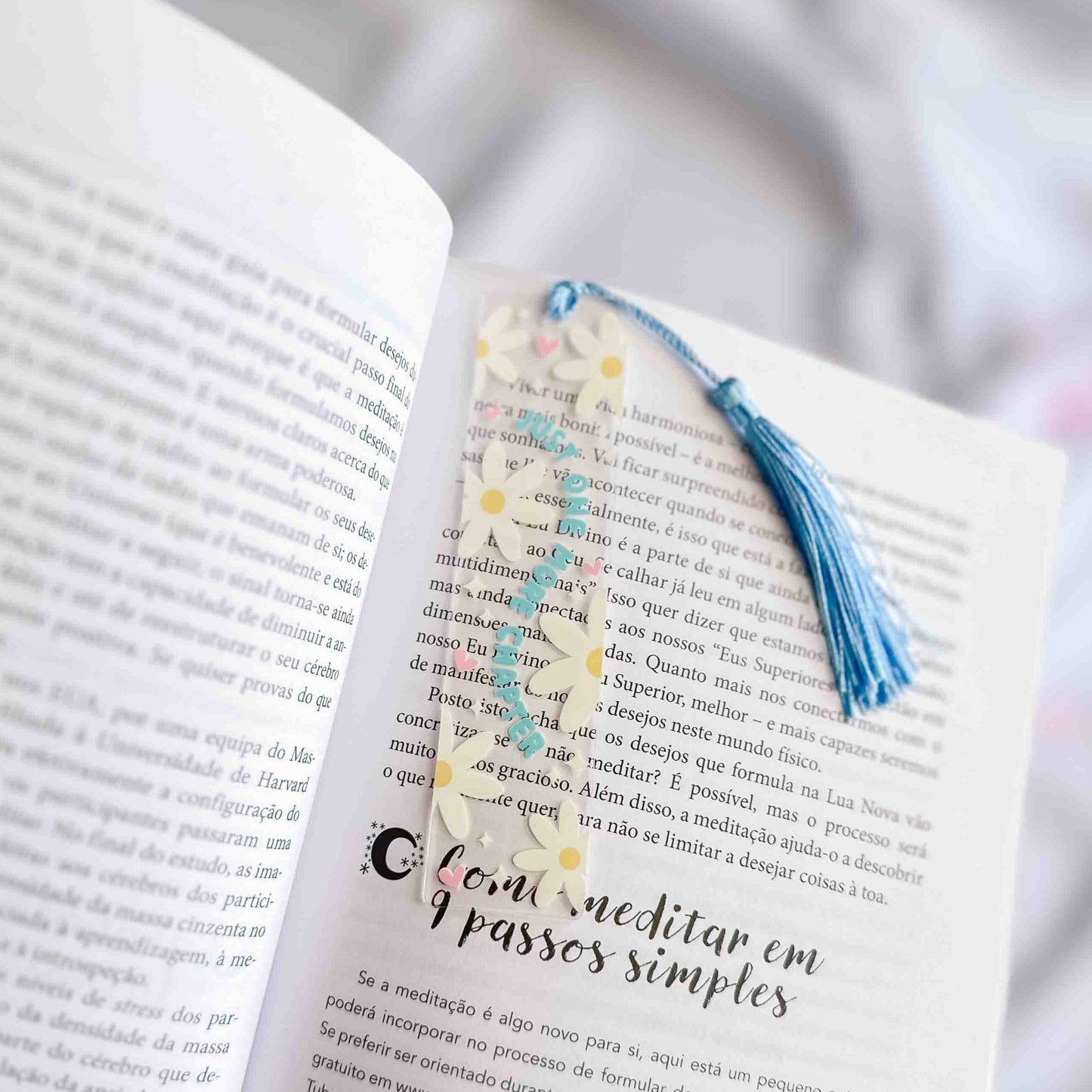 marcador de livro em acrilico com impressão de margaridas, corações e estrelinhas, com o dizer "just one more chapter"