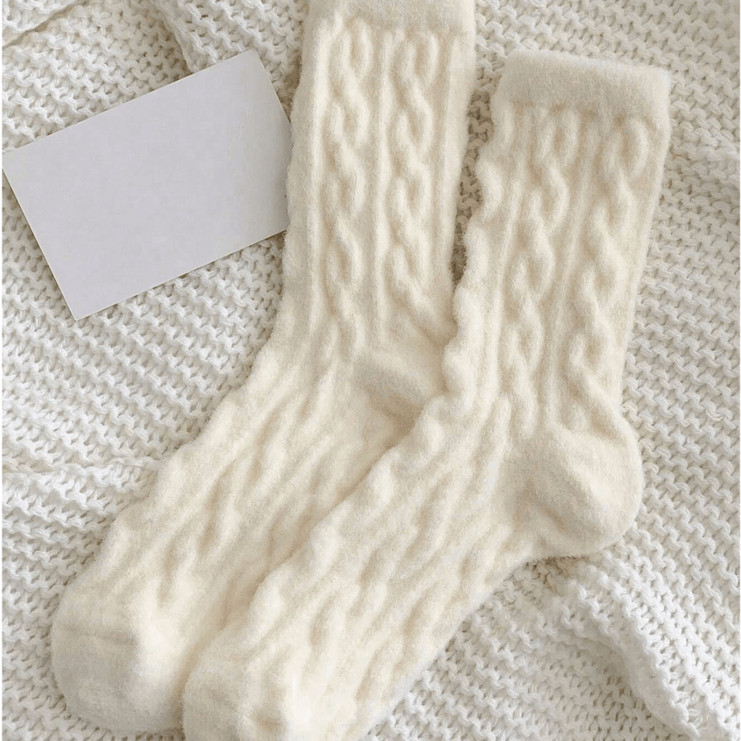 meias brancas fofinhas com textura, grossas e quentes sobre uma manta de lã branca