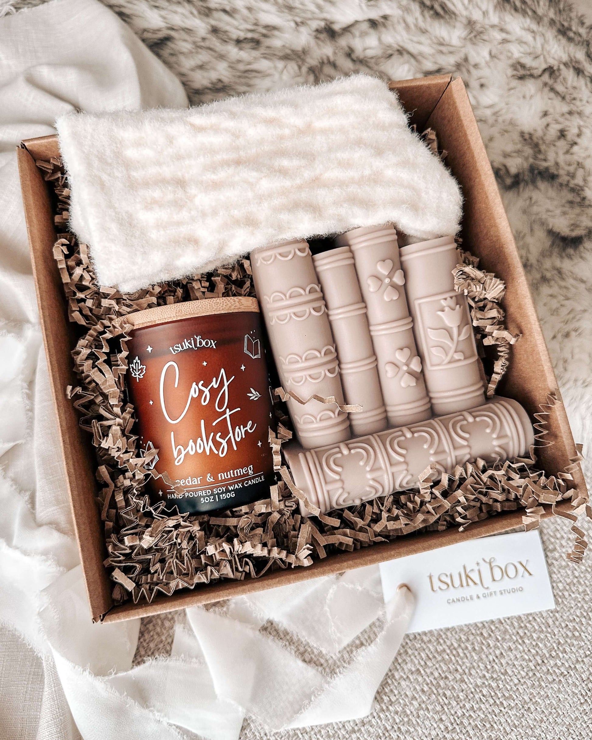 Caixa presente cozy com vela aromática, vela decorativa em forma de livros e meias em tom creme